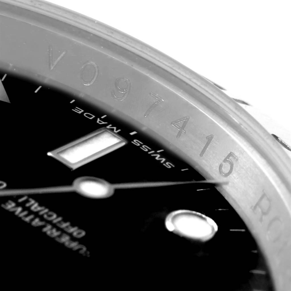 This close-up image of a Rolex Explorer 16570 Men's Stainless Steel Black Dial 16570 Men's Stainless Steel Black Dial watch shows a partial view of the dial, hands, and serial number engraved on the inner bezel.
