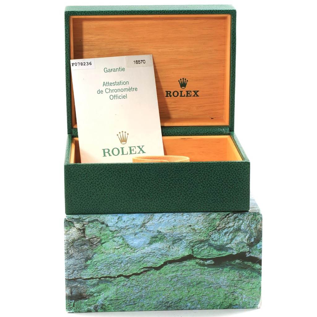 This image shows an open green Rolex box with a warranty card inside, featuring the Explorer model logo.