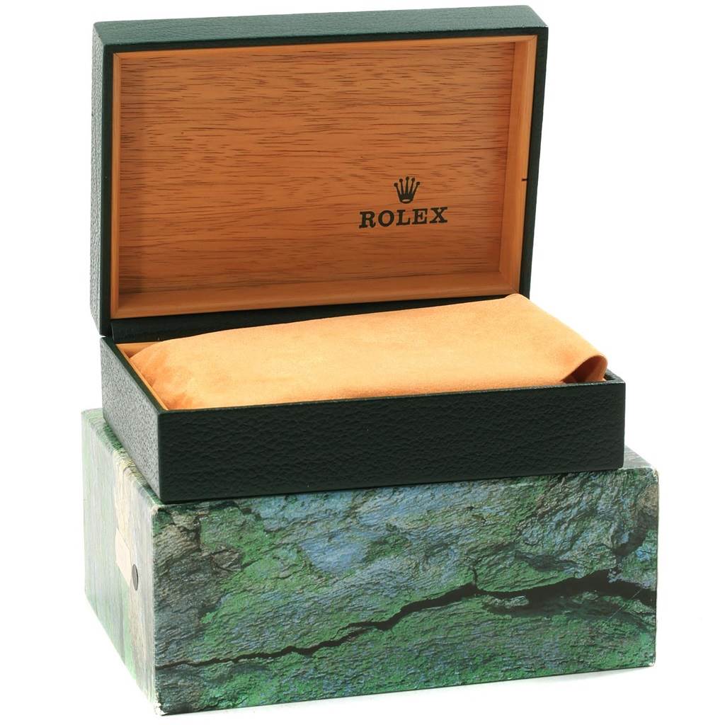 The image shows an open Rolex watch box for the Explorer model, featuring a lid with a wood finish and a logo inside.