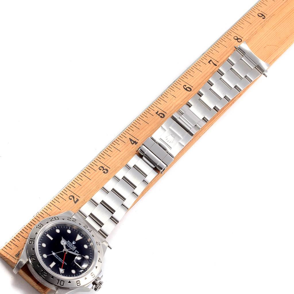 The image shows a Rolex Explorer 16570 Men's Stainless Steel Black Dial 16570 Men's Stainless Steel Black Dial watch with a silver metal bracelet laid next to a ruler for measurement.