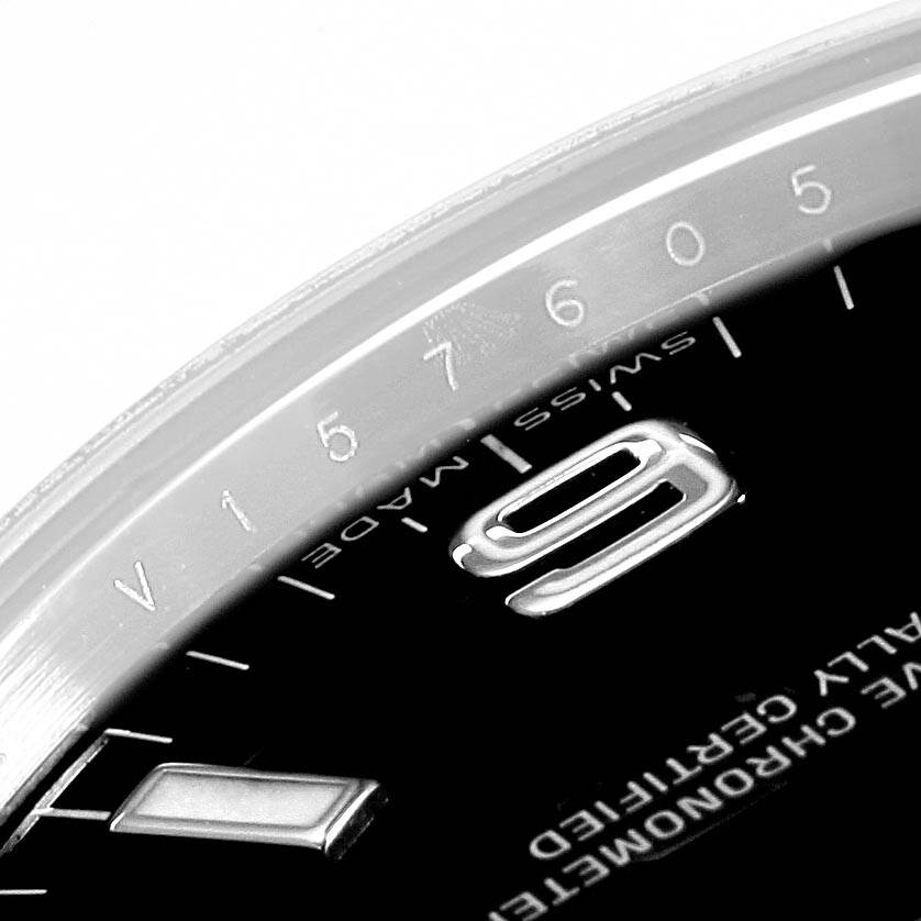A close-up of a Rolex Explorer 114270 Men's Stainless Steel Black Dial 114270 Men's Stainless Steel Black Dial watch showing parts of the dial, numeral 9, and the outer bezel.