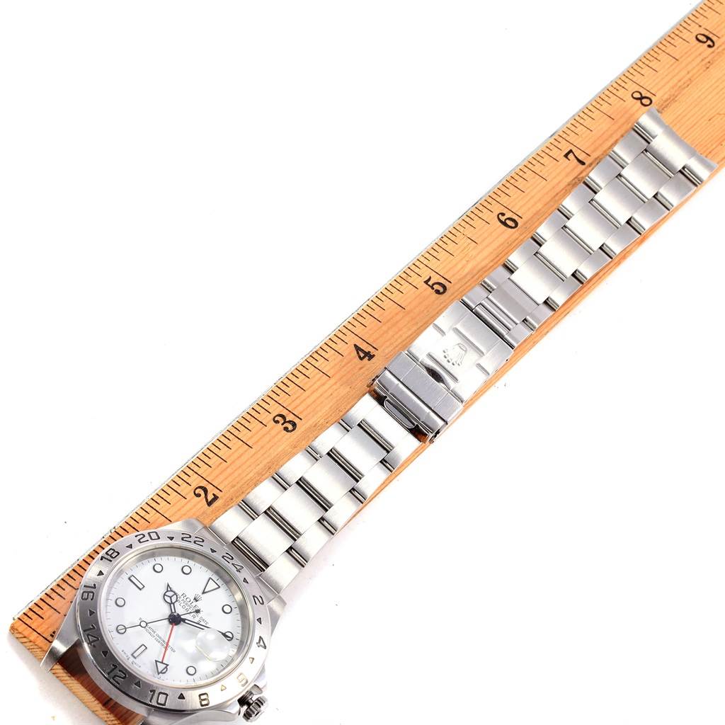 The Rolex Explorer 16570 Men's Stainless Steel White Dial 16570 Men's Stainless Steel White Dial watch is shown from above, revealing the full bracelet and the face next to a ruler for scale.