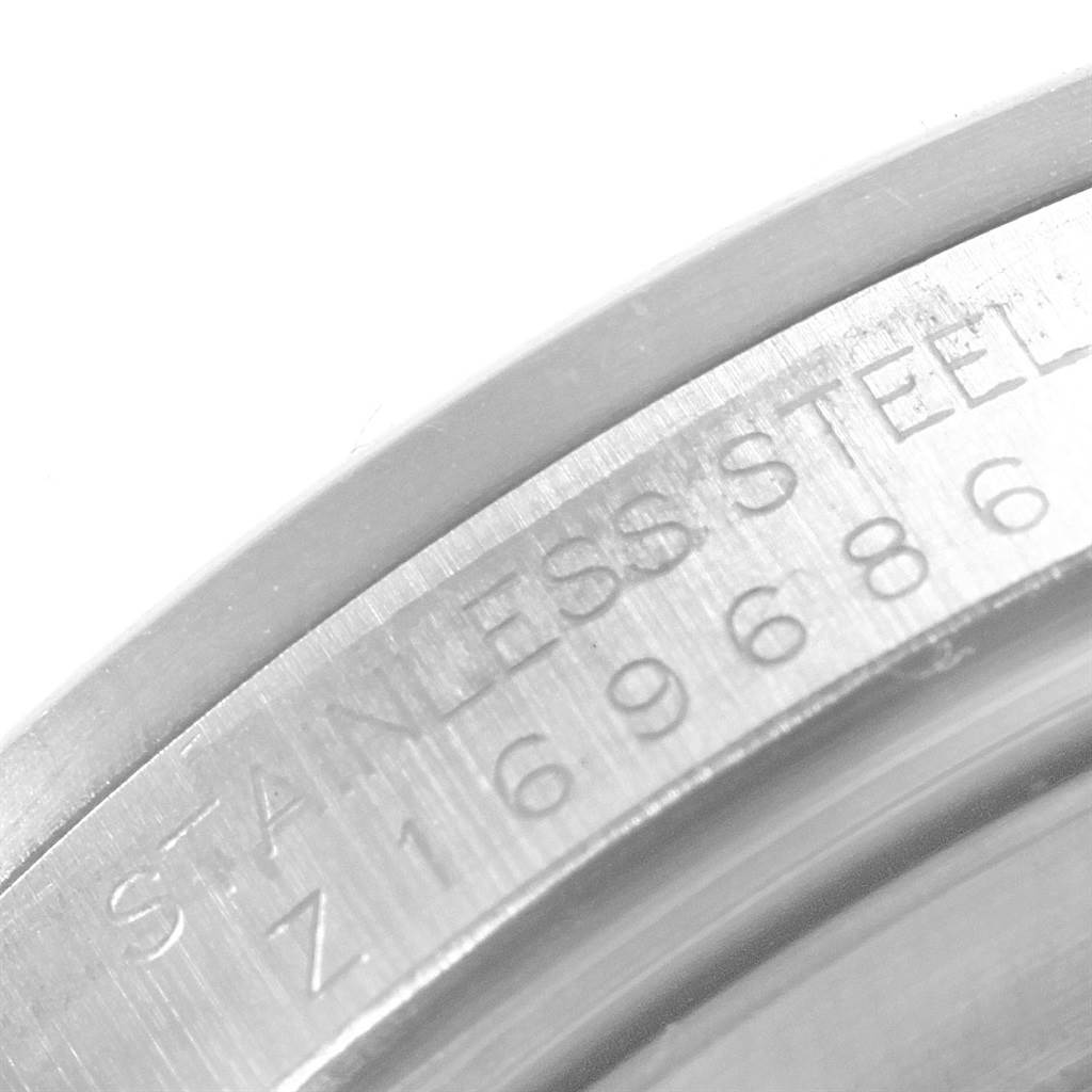 This close-up image shows the stainless steel bezel and part of the serial number of a Rolex Explorer 16570 Men's Stainless Steel White Dial 16570 Men's Stainless Steel White Dial watch.