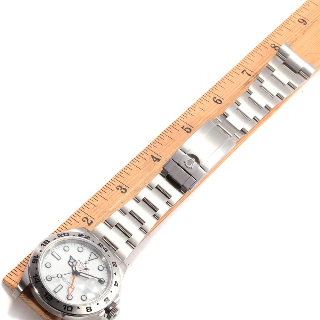 The image shows a Rolex Explorer 216570 Men's Stainless Steel White Dial 216570 Men's Stainless Steel White Dial watch laid next to a ruler, displaying its bracelet, clasp, and dial from a top-down angle.