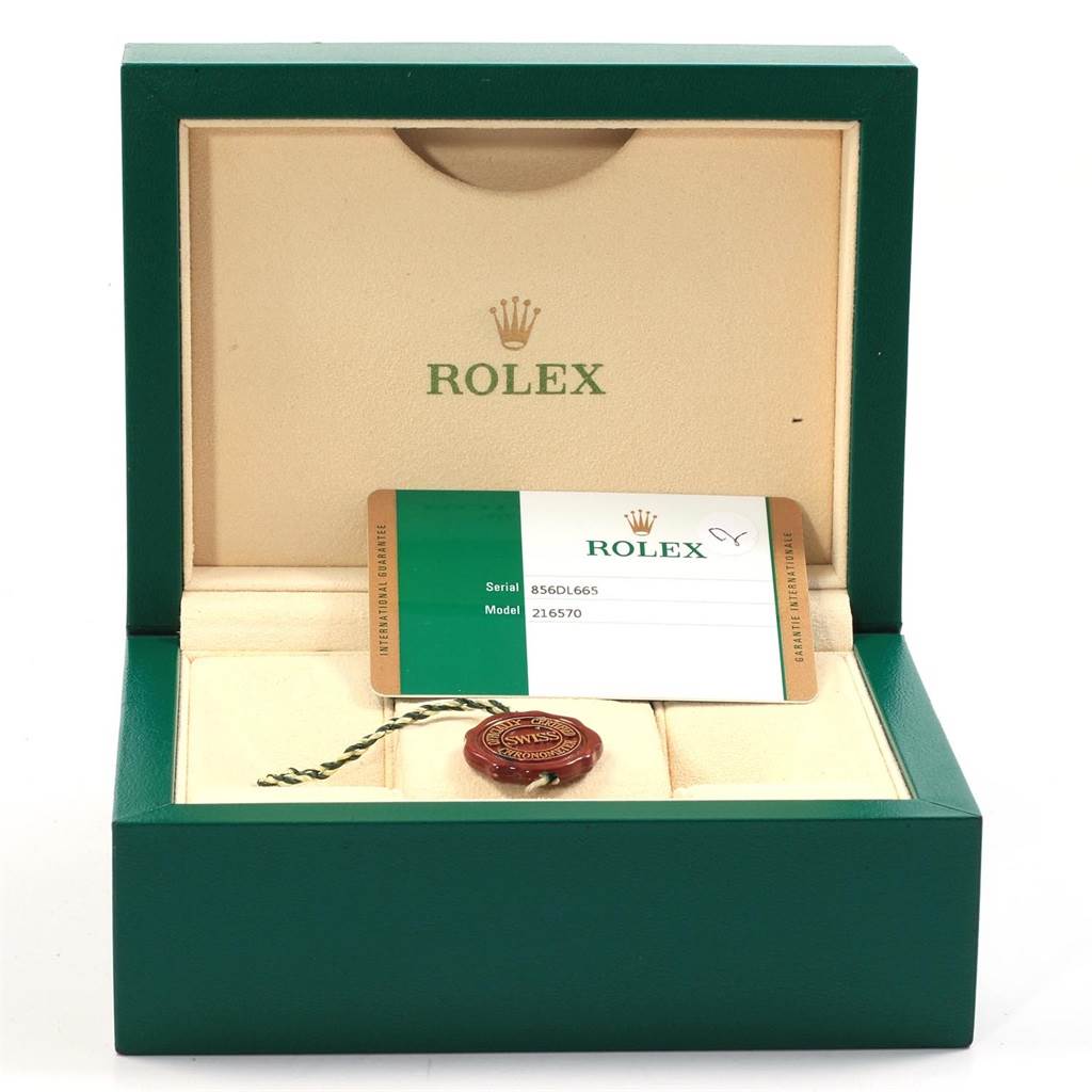 The image shows a Rolex Explorer 216570 Men's Stainless Steel White Dial 216570 Men's Stainless Steel White Dial watch box containing a warranty card and a tag inside.