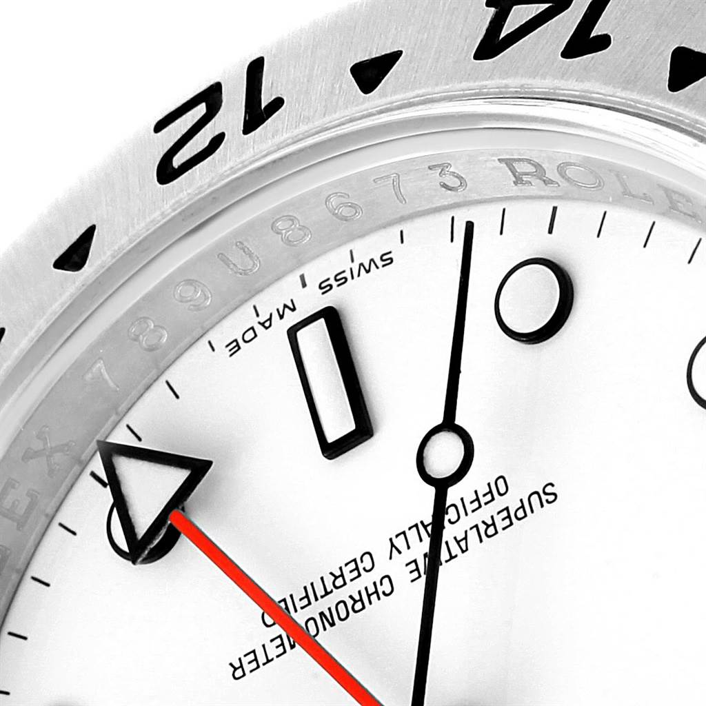This close-up image of a Rolex Explorer 16570 Men's Stainless Steel White Dial 16570 Men's Stainless Steel White Dial watch shows the bezel, part of the dial, and the hands, including the red second hand.