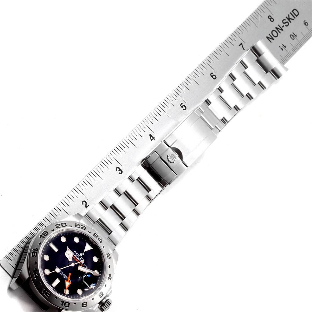 The image shows a Rolex Explorer 216570 Men's Stainless Steel Black Dial 216570 Men's Stainless Steel Black Dial watch with its face and metal bracelet band displayed alongside a measuring ruler.