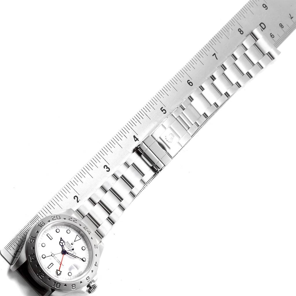 The image shows a sideways view of the Rolex Explorer 16570 Men's Stainless Steel White Dial 16570 Men's Stainless Steel White Dial watch with its bracelet and a ruler for scale.