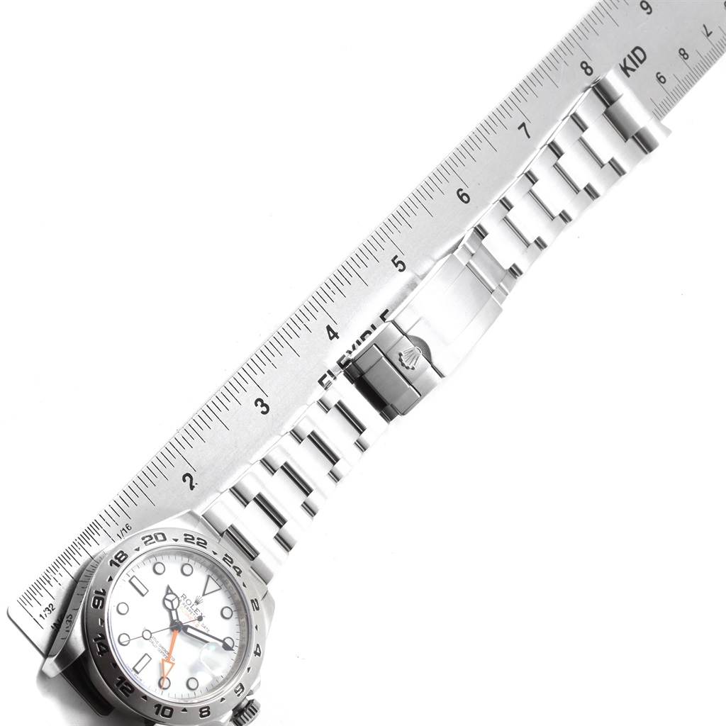 The image shows a top-down view of the Rolex Explorer 216570 Men's Stainless Steel White Dial 216570 Men's Stainless Steel White Dial watch, including its face, bezel, and entire metal bracelet next to a ruler.