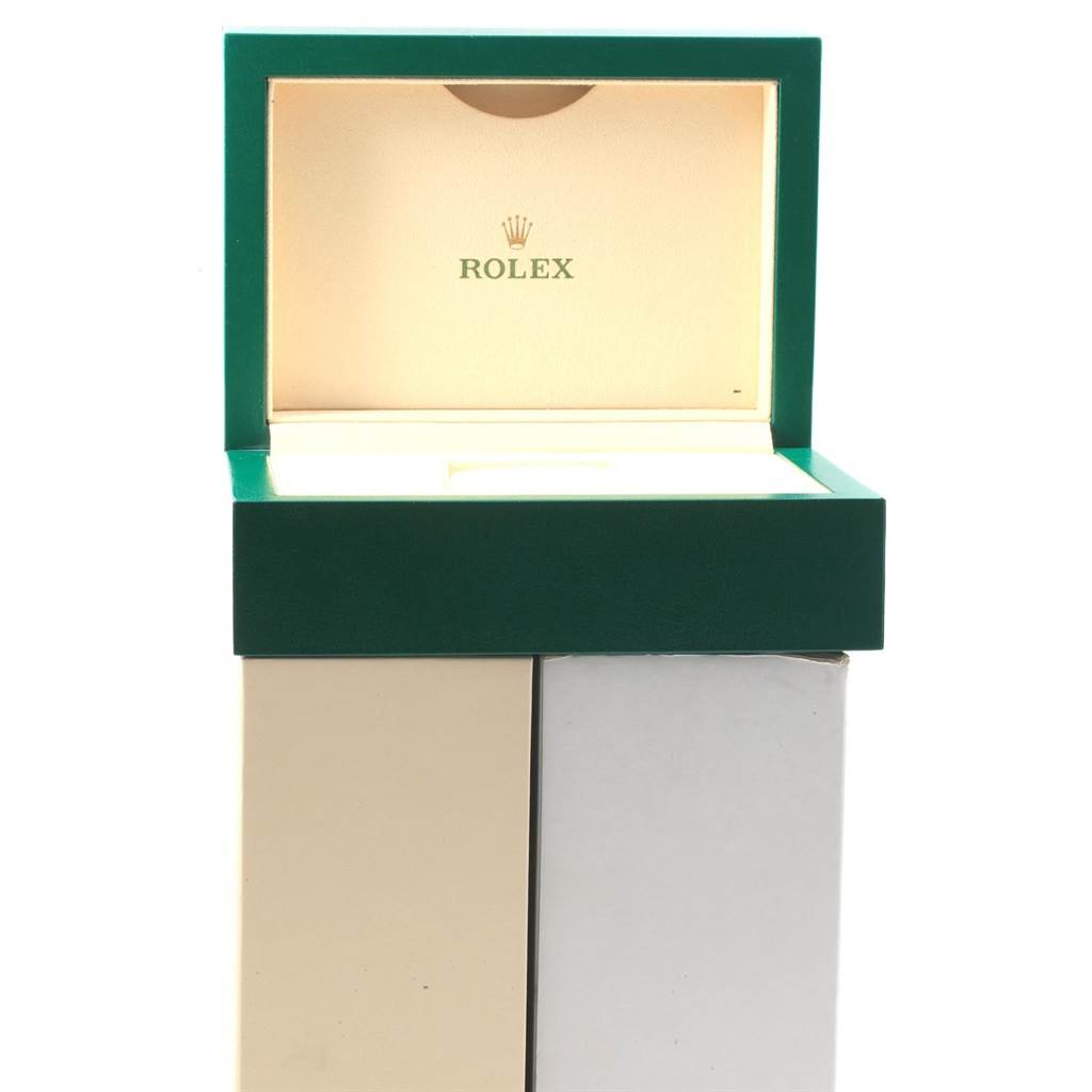 The image shows an open green and beige Rolex watch box for the Explorer model.