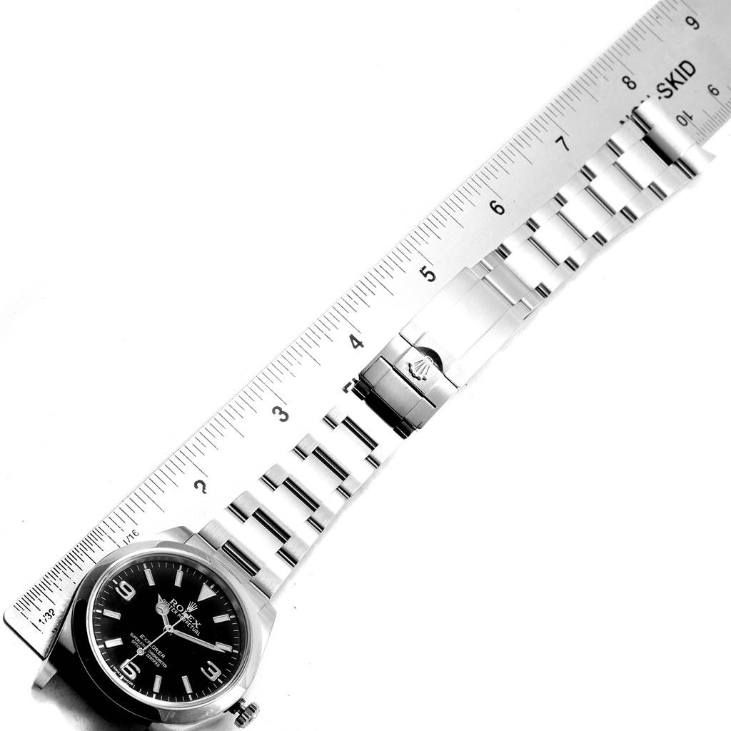 The image shows the face and bracelet of a Rolex Explorer 214270 Men
s Stainless Steel Black Dial 214270 Men
s Stainless Steel Black Dial watch, aligned with a ruler for measurement.