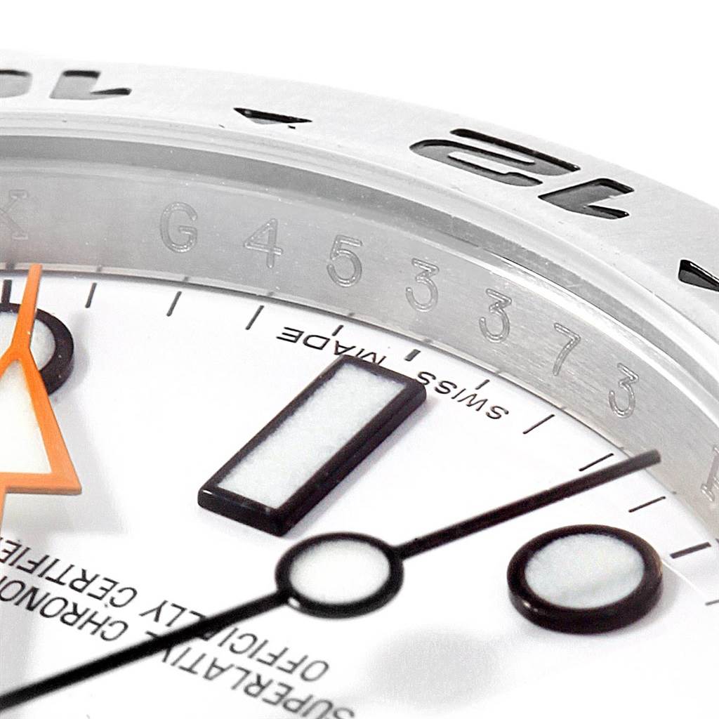 This close-up image of a Rolex Explorer 216570 Men's Stainless Steel White Dial 216570 Men's Stainless Steel White Dial watch shows the face, hands, and part of the bezel with engraved numbers.