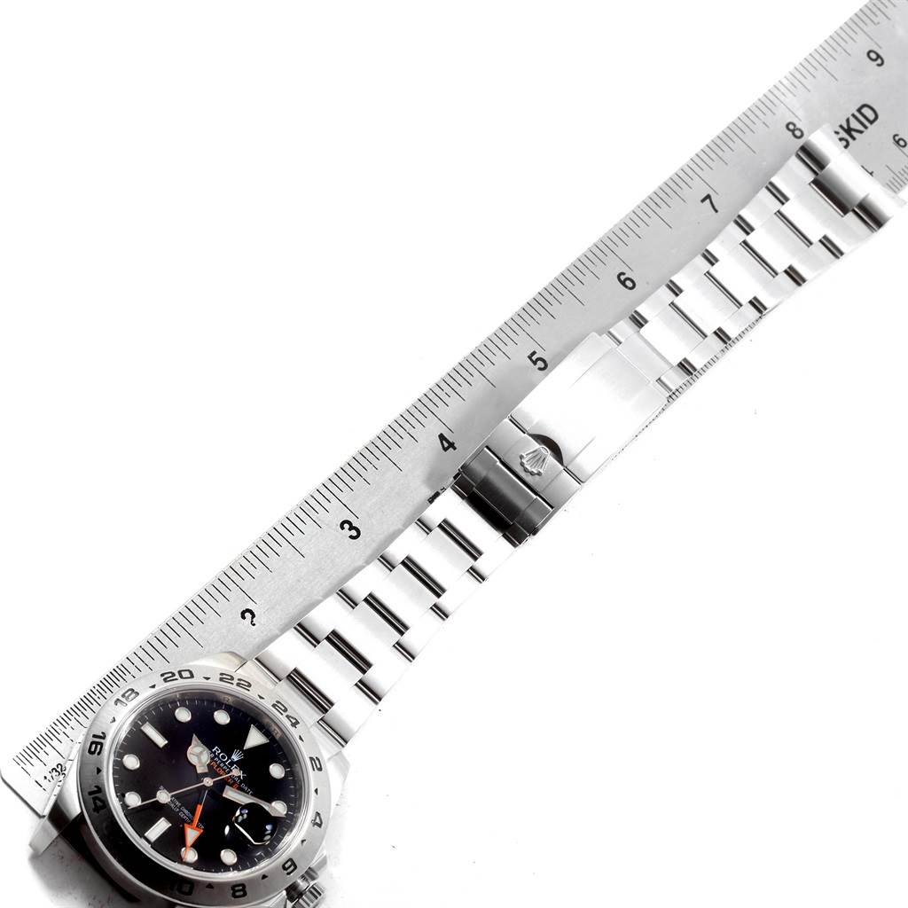 The image shows a Rolex Explorer 216570 Men's Stainless Steel Black Dial 216570 Men's Stainless Steel Black Dial watch from a top-down angle, displaying the face, bezel, and part of the bracelet against a ruler for scale.