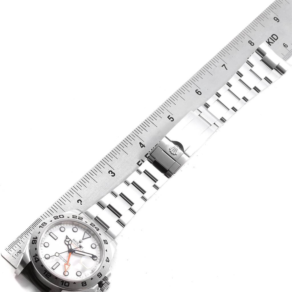 The image shows a Rolex Explorer 216570 Men's Stainless Steel White Dial 216570 Men's Stainless Steel White Dial watch laid flat with a ruler measuring its metal bracelet and clasp.