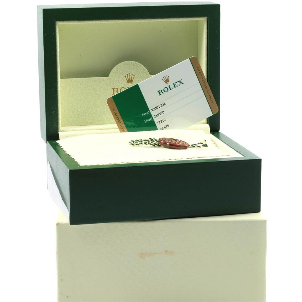 The image shows a Rolex Explorer 216570 Men's Stainless Steel White Dial 216570 Men's Stainless Steel White Dial watch box open at an angle, revealing a warranty card and a tag.