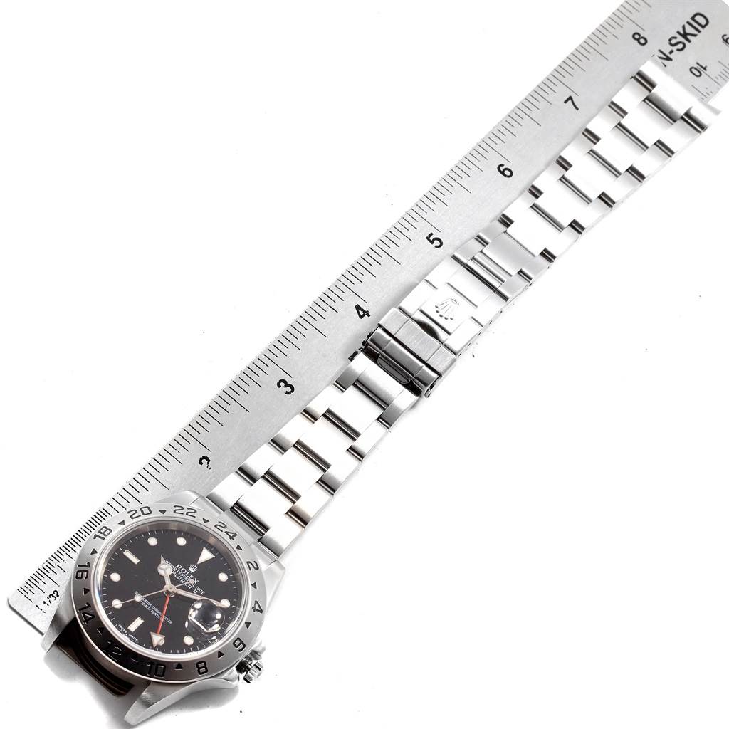 The image shows a Rolex Explorer 16570 Men's Stainless Steel Black Dial 16570 Men's Stainless Steel Black Dial watch laid flat with a ruler beside it, illustrating the full bracelet and the face.