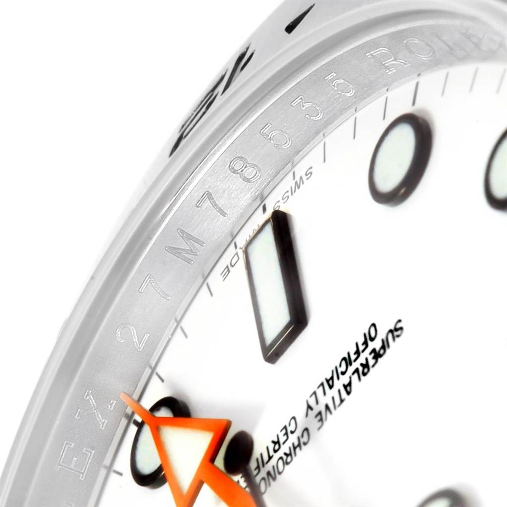 The image shows a close-up of the dial and bezel of the Rolex Explorer 216570 Men's Stainless Steel White Dial 216570 Men's Stainless Steel White Dial, highlighting hour markers and the engraved bezel.