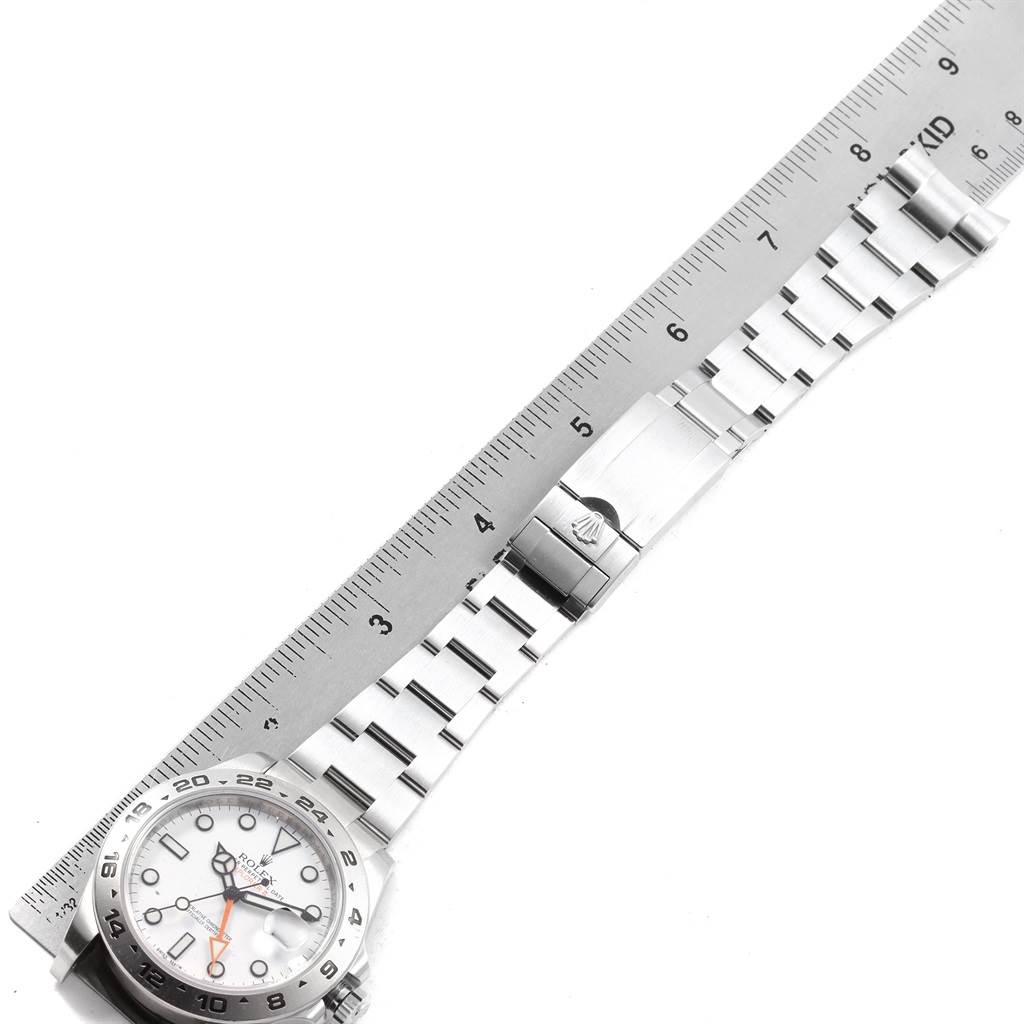 The image shows a Rolex Explorer 216570 Men's Stainless Steel White Dial 216570 Men's Stainless Steel White Dial watch and its stainless steel bracelet laid flat next to a ruler.