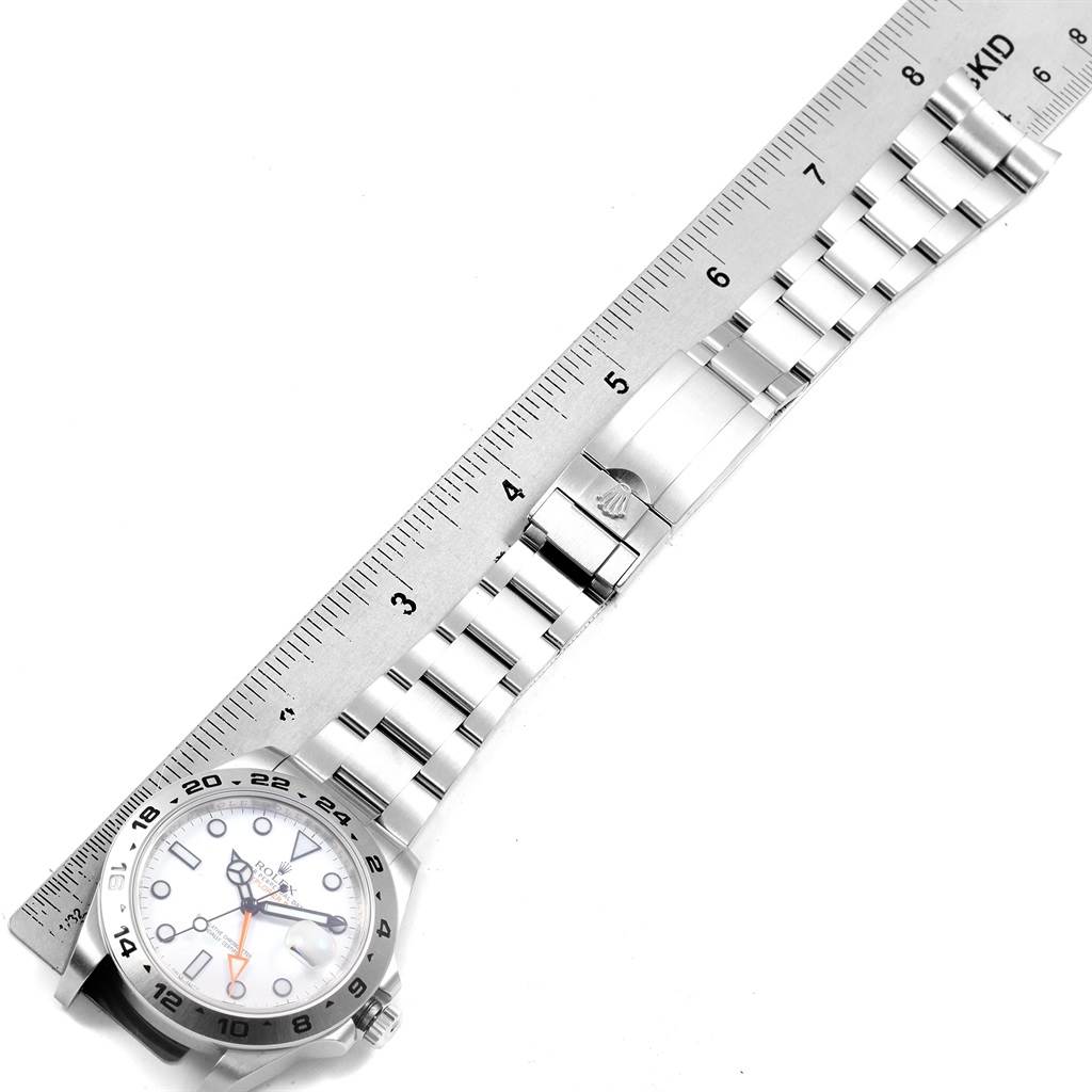 The image shows a Rolex Explorer 216570 Men's Stainless Steel White Dial 216570 Men's Stainless Steel White Dial watch laid flat with its stainless steel bracelet alongside a ruler.