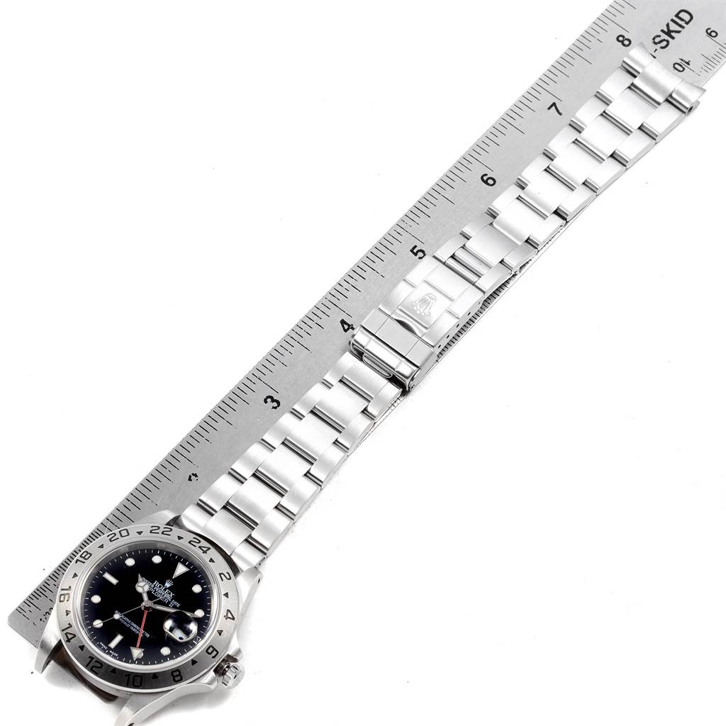 The image shows a Rolex Explorer 16570 Men
s Stainless Steel Black Dial 16570 Men
s Stainless Steel Black Dial watch, laid flat next to a ruler measuring its metal bracelet and clasp.