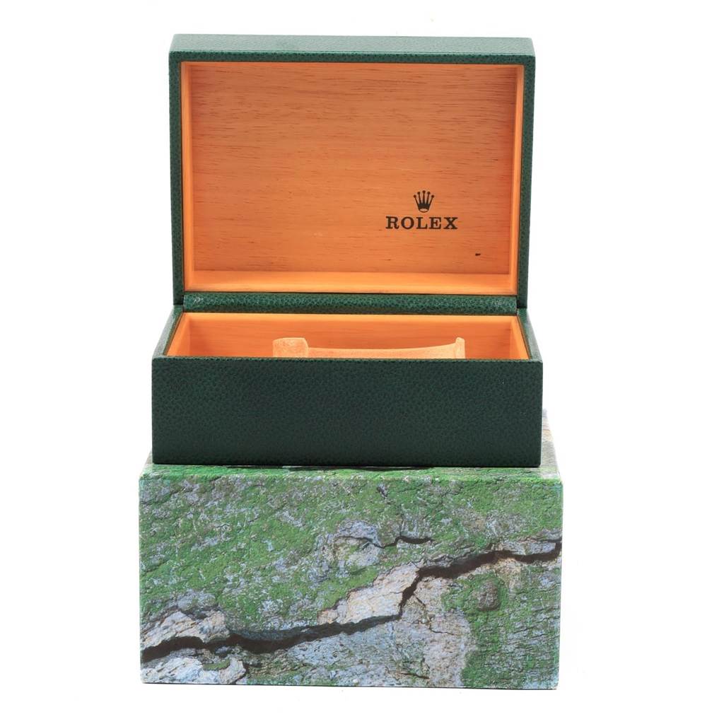 The image shows an open green Rolex box (for an Explorer model) with a wooden interior and the Rolex logo inside.