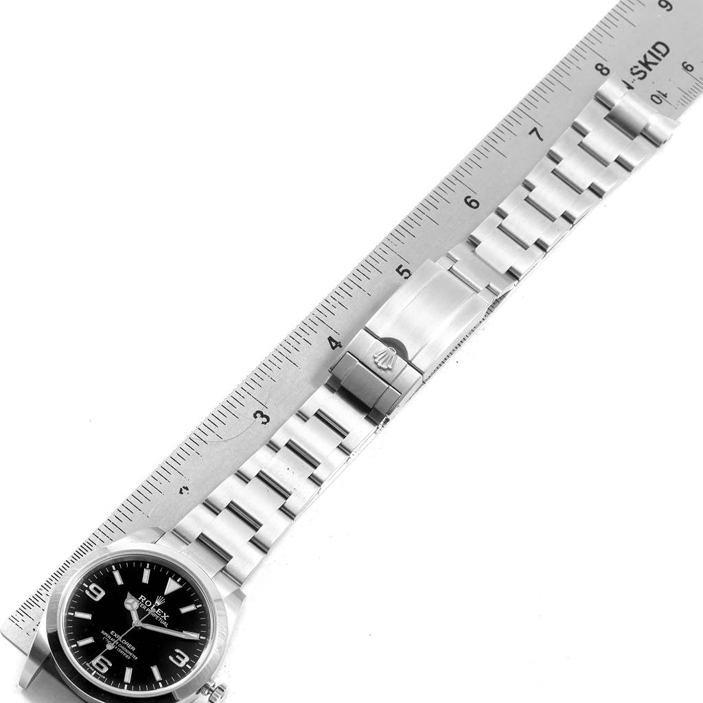 This image shows a side view of a Rolex Explorer 214270 Men's Stainless Steel Black Dial 214270 Men's Stainless Steel Black Dial, focusing on the watch's face, bracelet, and clasp, measured against a ruler.