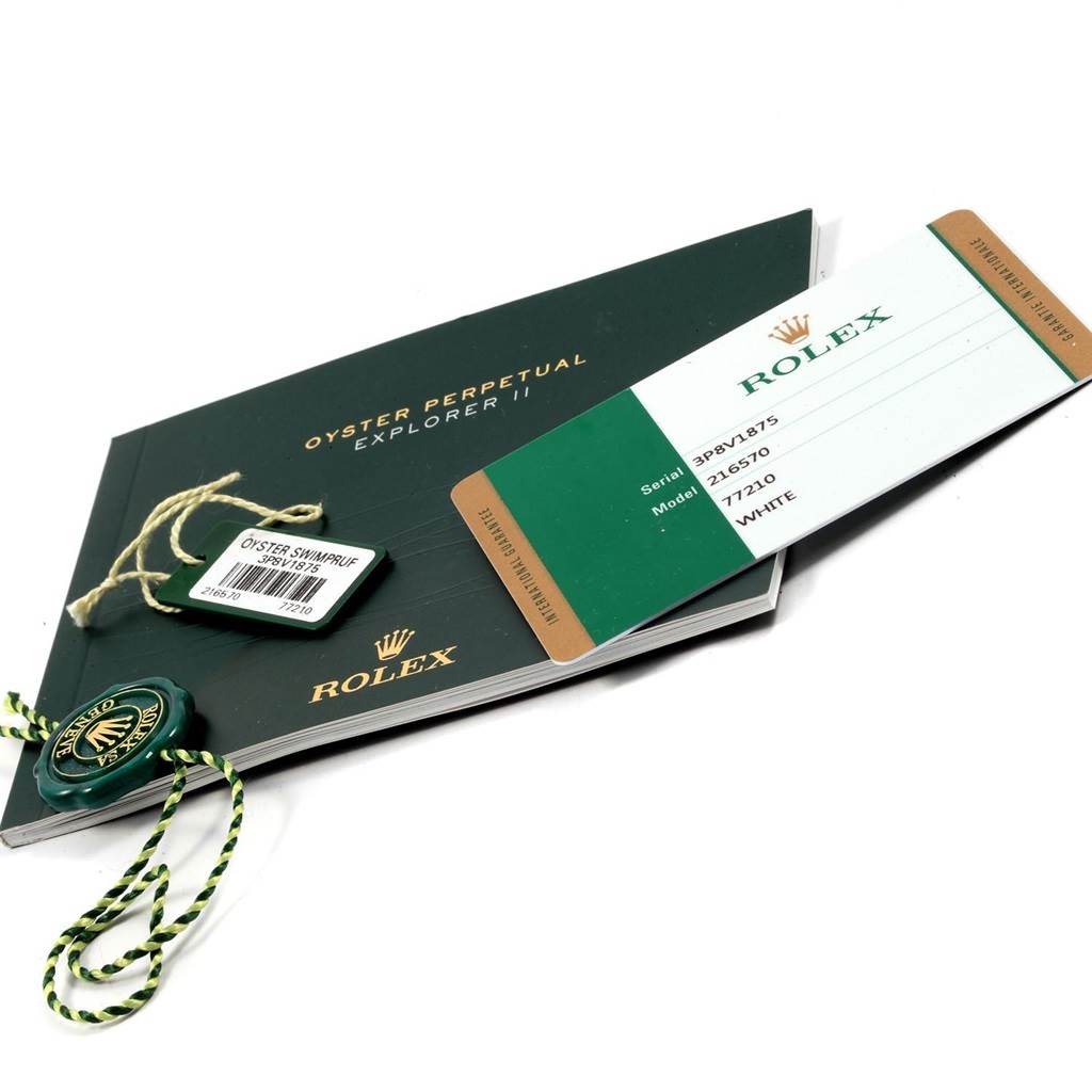 The image shows a Rolex Explorer 216570 Men
s Stainless Steel White Dial 216570 Men
s Stainless Steel White Dial model booklet, a tag, and an international guarantee card at an angled perspective.