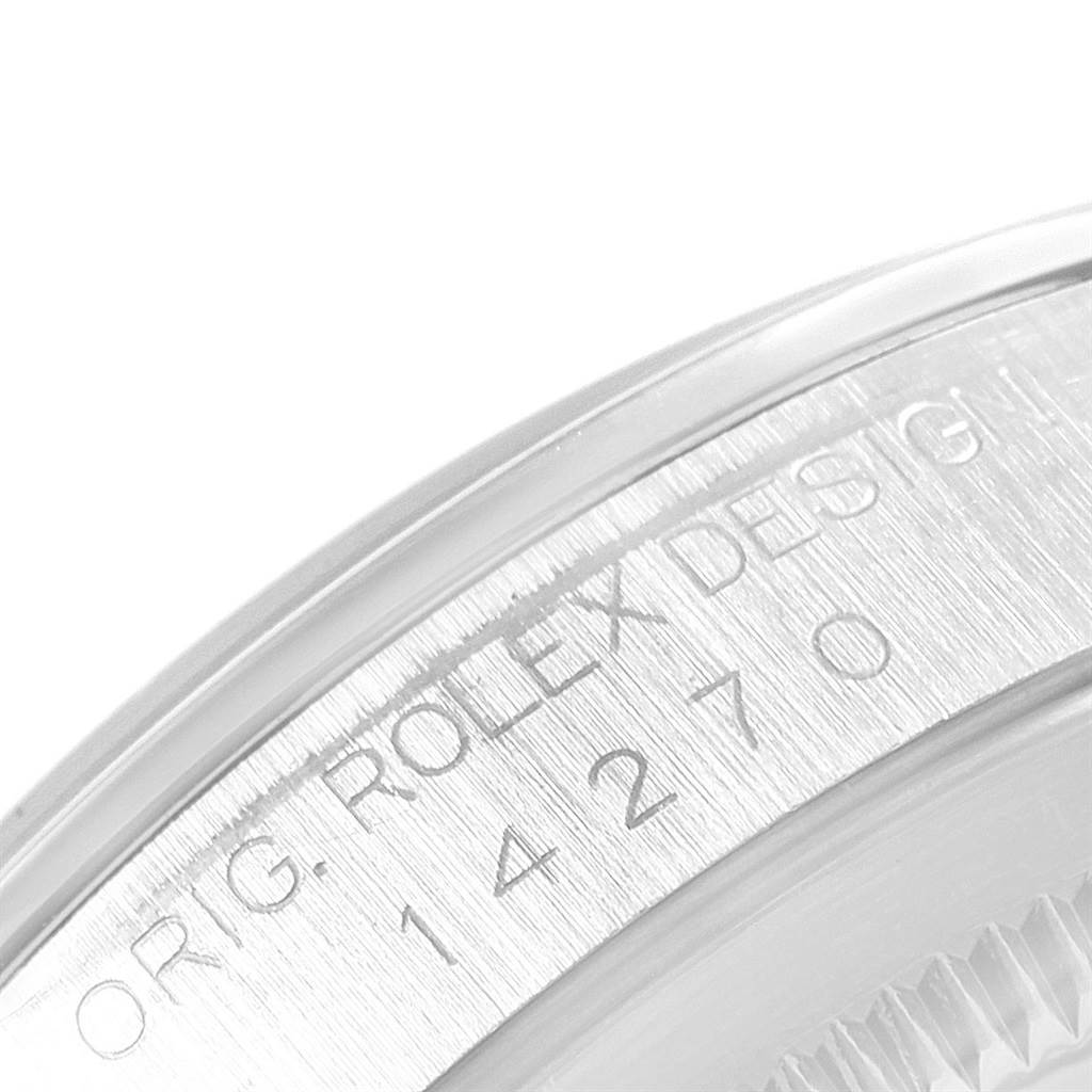 The image shows a close-up of the serial number and "ROLEX DESIGN" engraving on the side of the Rolex Explorer 14270 Men
s Stainless Steel Black Dial 14270 Men
s Stainless Steel Black Dial model watch
s case.