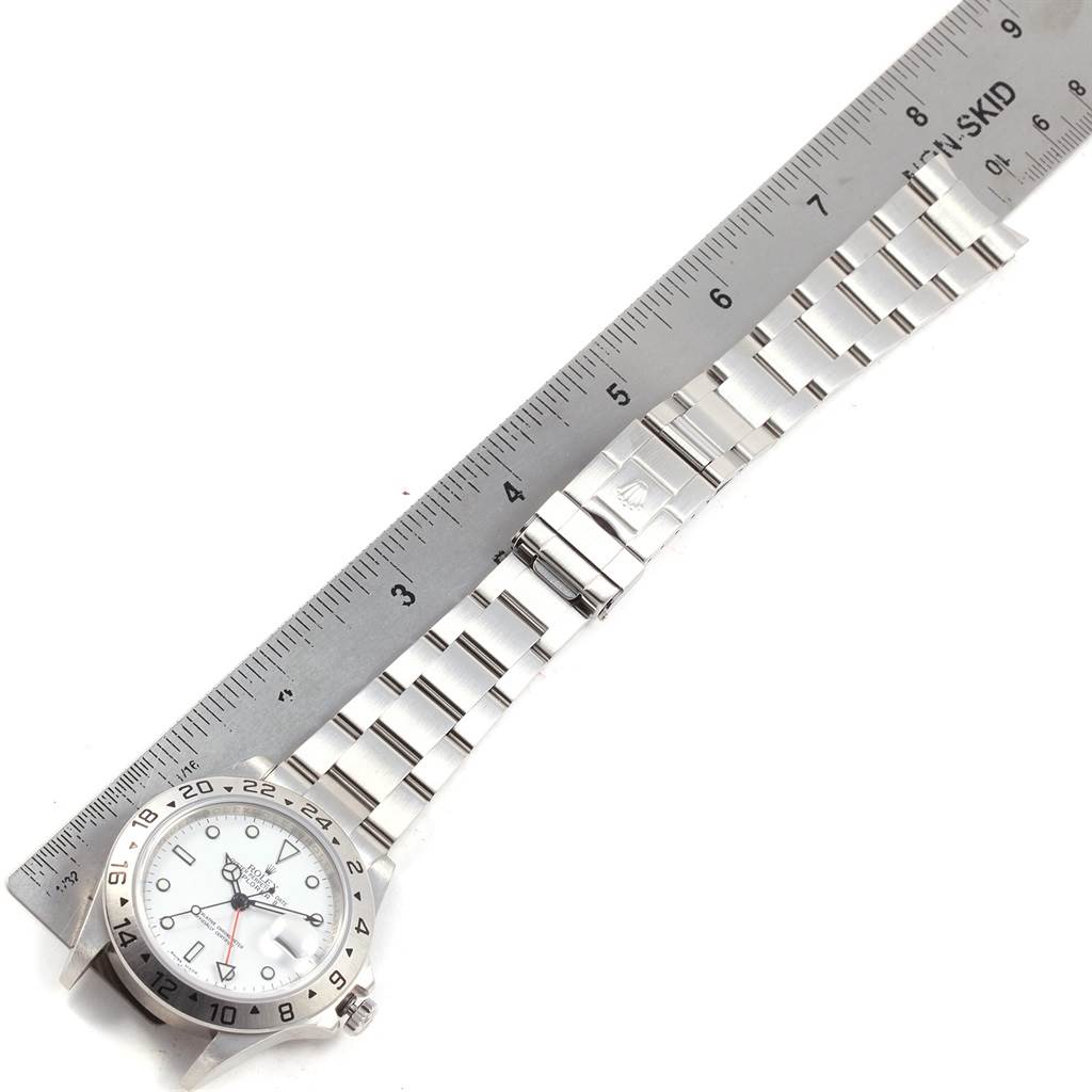 The image shows the Rolex Explorer 16570 Men's Stainless Steel White Dial 16570 Men's Stainless Steel White Dial model watch laid flat with a silver ruler measuring its band.
