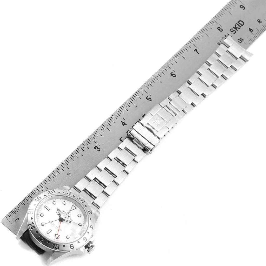 The image shows a Rolex Explorer 16570 Men's Stainless Steel White Dial 16570 Men's Stainless Steel White Dial watch and its bracelet laid out next to a ruler, photographed from above.