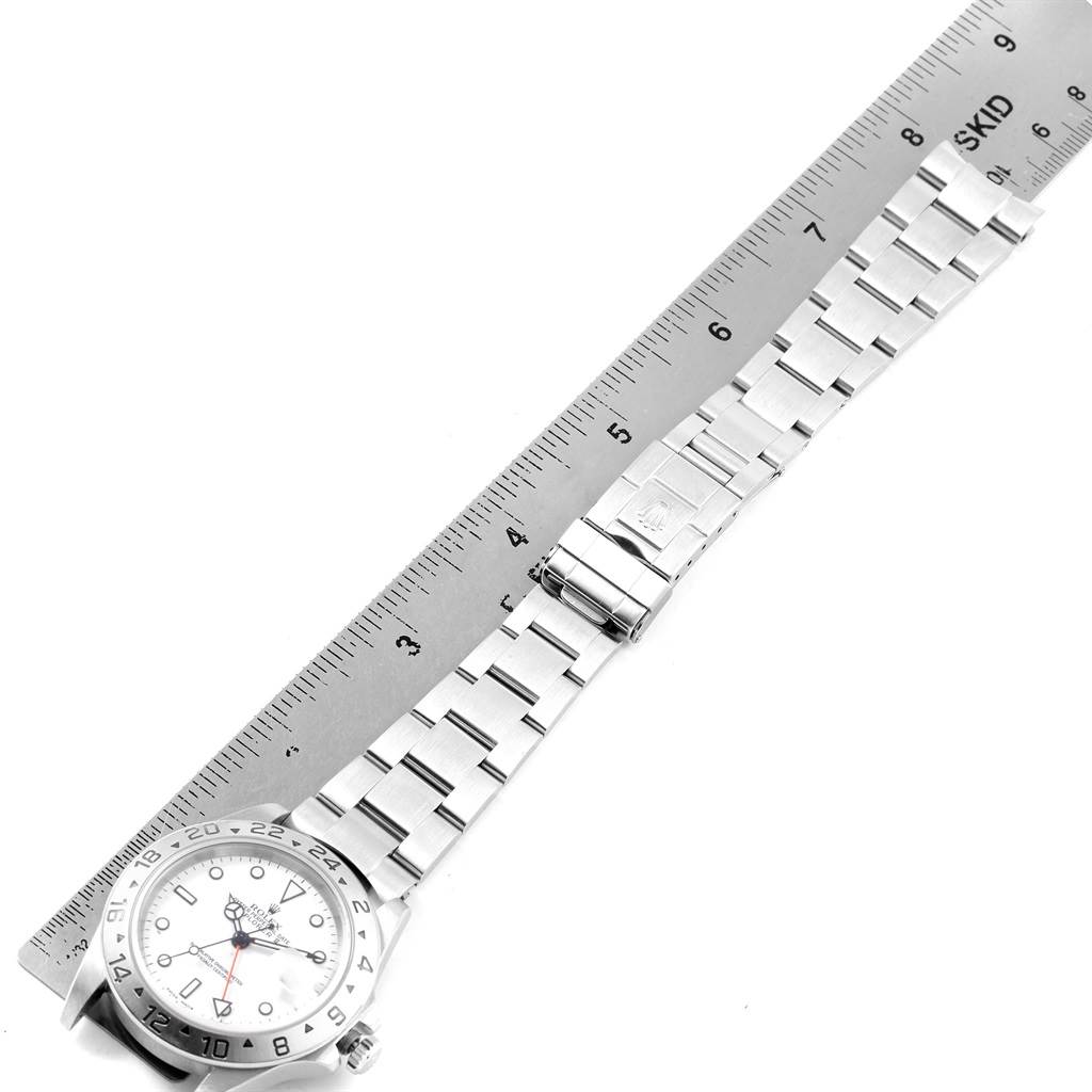 The image shows a Rolex Explorer 16570 Men's Stainless Steel White Dial 16570 Men's Stainless Steel White Dial watch laid flat with its bracelet fully extended, alongside a ruler for measurement.