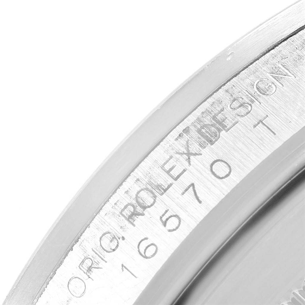 This image shows a close-up angle of the inner bezel of a Rolex Explorer 16570 Men's Stainless Steel White Dial 16570 Men's Stainless Steel White Dial model, displaying the "ORIG. ROLEX DESIGN" engraving and model number.