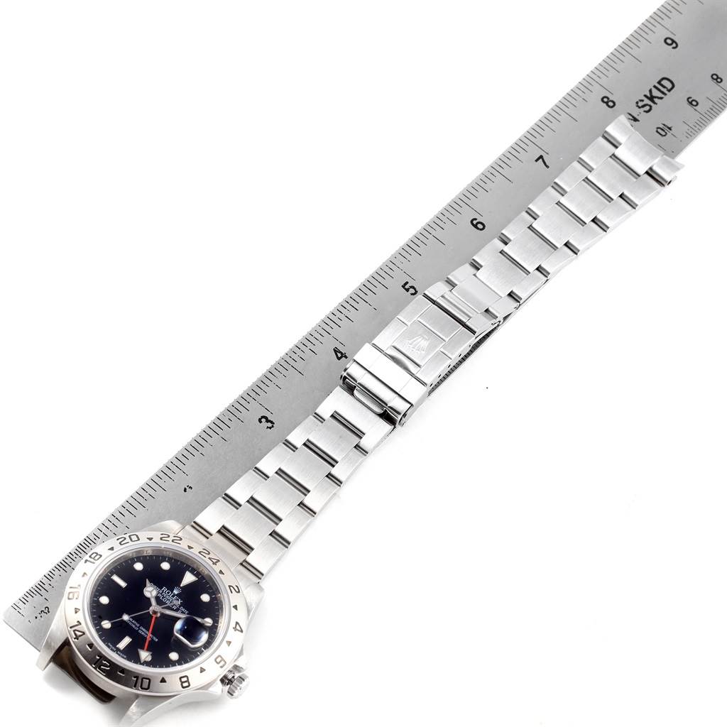 A top-down view of the Rolex Explorer 16570 Men's Stainless Steel Black Dial 16570 Men's Stainless Steel Black Dial watch shows the dial, bezel, and the full metal bracelet alongside a ruler.