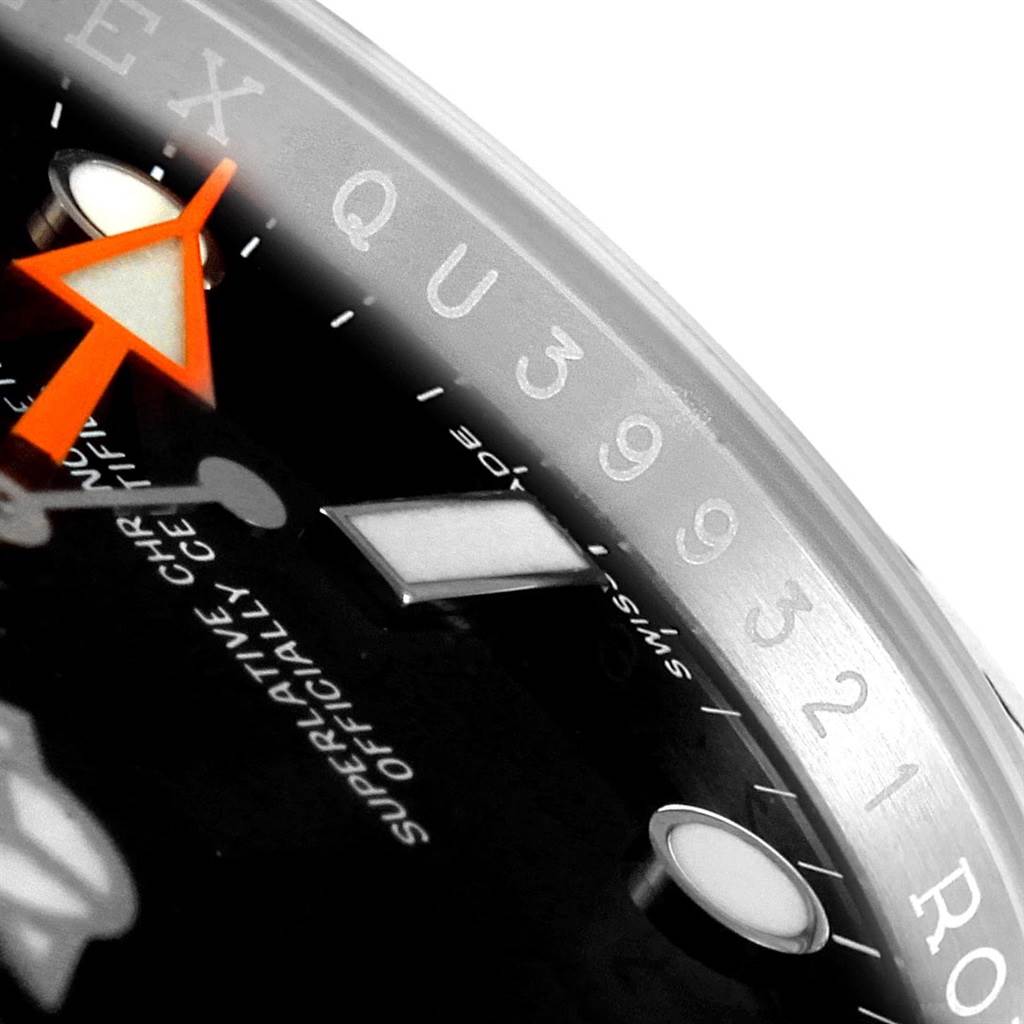 The image shows a close-up of a Rolex Explorer 216570 Men's Stainless Steel Black Dial 216570 Men's Stainless Steel Black Dial watch, highlighting part of the bezel, the dial, and the orange hand.