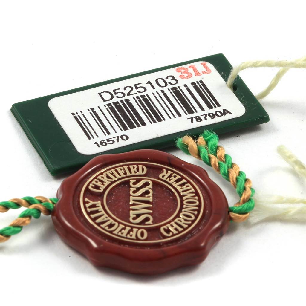 The image shows a green tag with a barcode and model information, along with a wax seal-like tag for a Rolex Explorer 16570 Men
s Stainless Steel Black Dial 16570 Men
s Stainless Steel Black Dial watch.