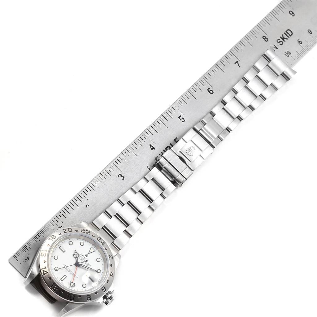 The image shows a Rolex Explorer 16570 Men's Stainless Steel White Dial 16570 Men's Stainless Steel White Dial model watch laid flat alongside a ruler, displaying the face, bezel, and bracelet.