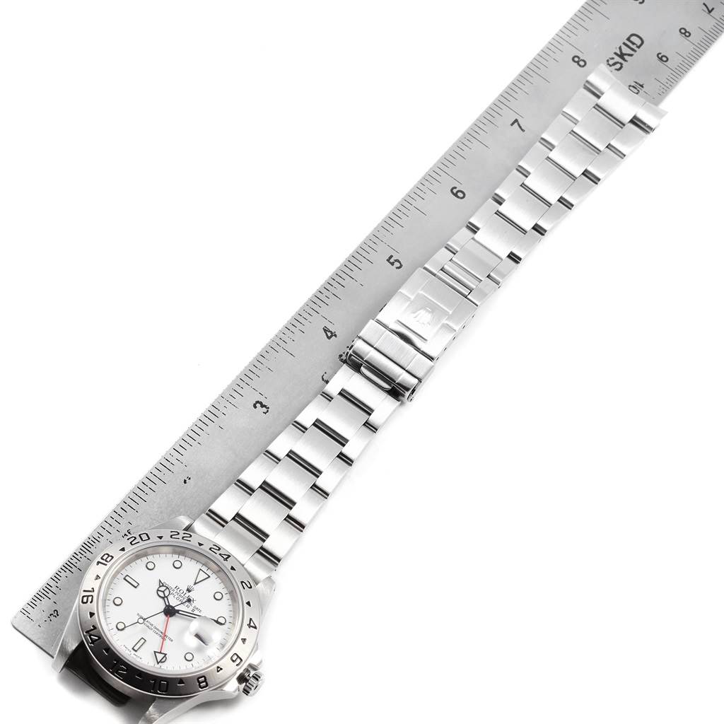 The image shows a top-down view of a Rolex Explorer 16570 Men's Stainless Steel White Dial 16570 Men's Stainless Steel White Dial watch with its stainless steel bracelet beside a ruler.