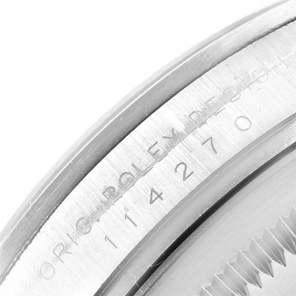 The image shows a close-up of the engraved serial number on the case of a Rolex Explorer 114270 Men's Stainless Steel Black Dial 114270 Men's Stainless Steel Black Dial watch.