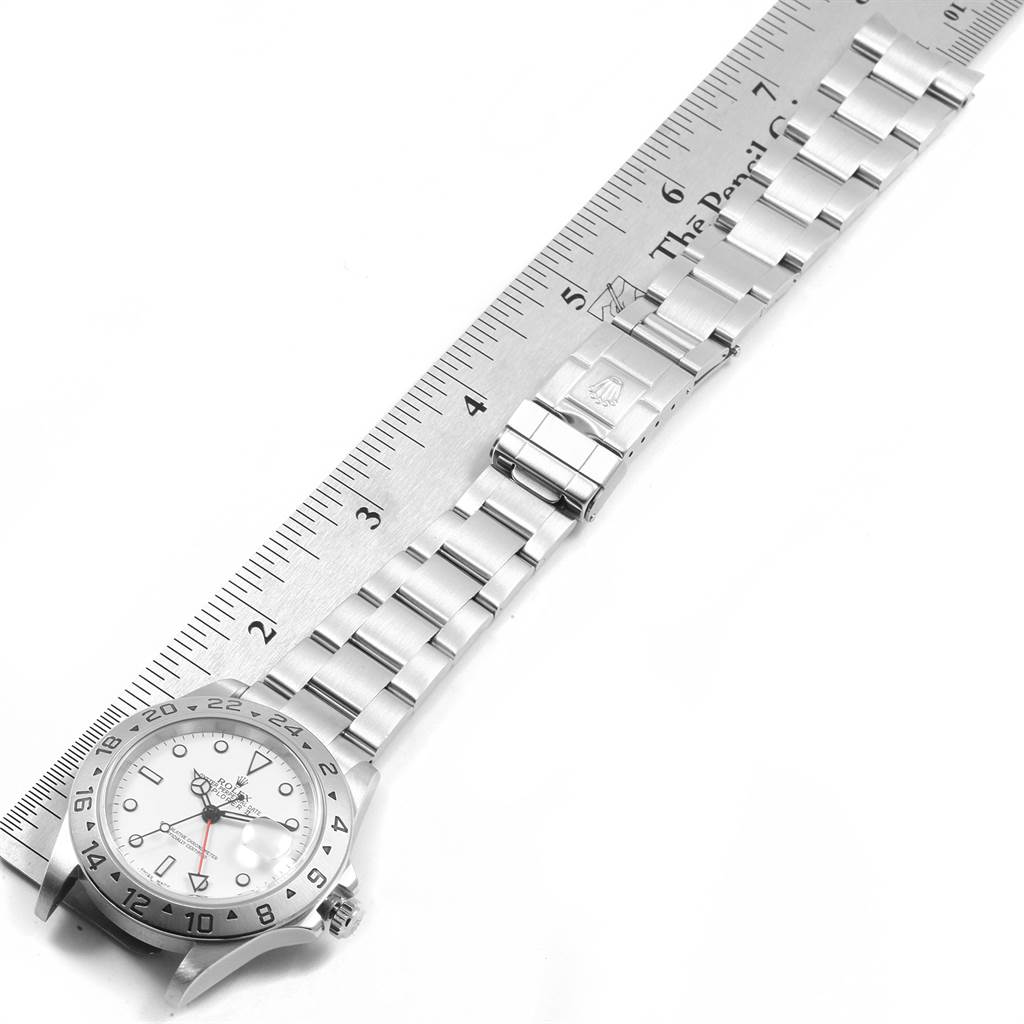 This image shows the Rolex Explorer 16570 Men's Stainless Steel White Dial 16570 Men's Stainless Steel White Dial watch laid flat with the face and full metal bracelet clearly visible, displayed alongside a ruler.
