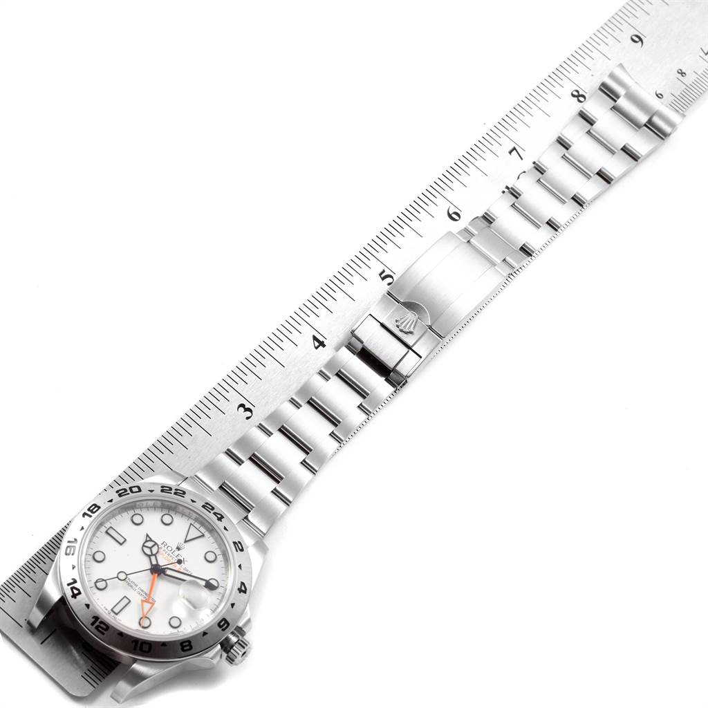 The image shows the face and bracelet of the Rolex Explorer 216570 Men's Stainless Steel White Dial 216570 Men's Stainless Steel White Dial watch with a ruler measuring its length.