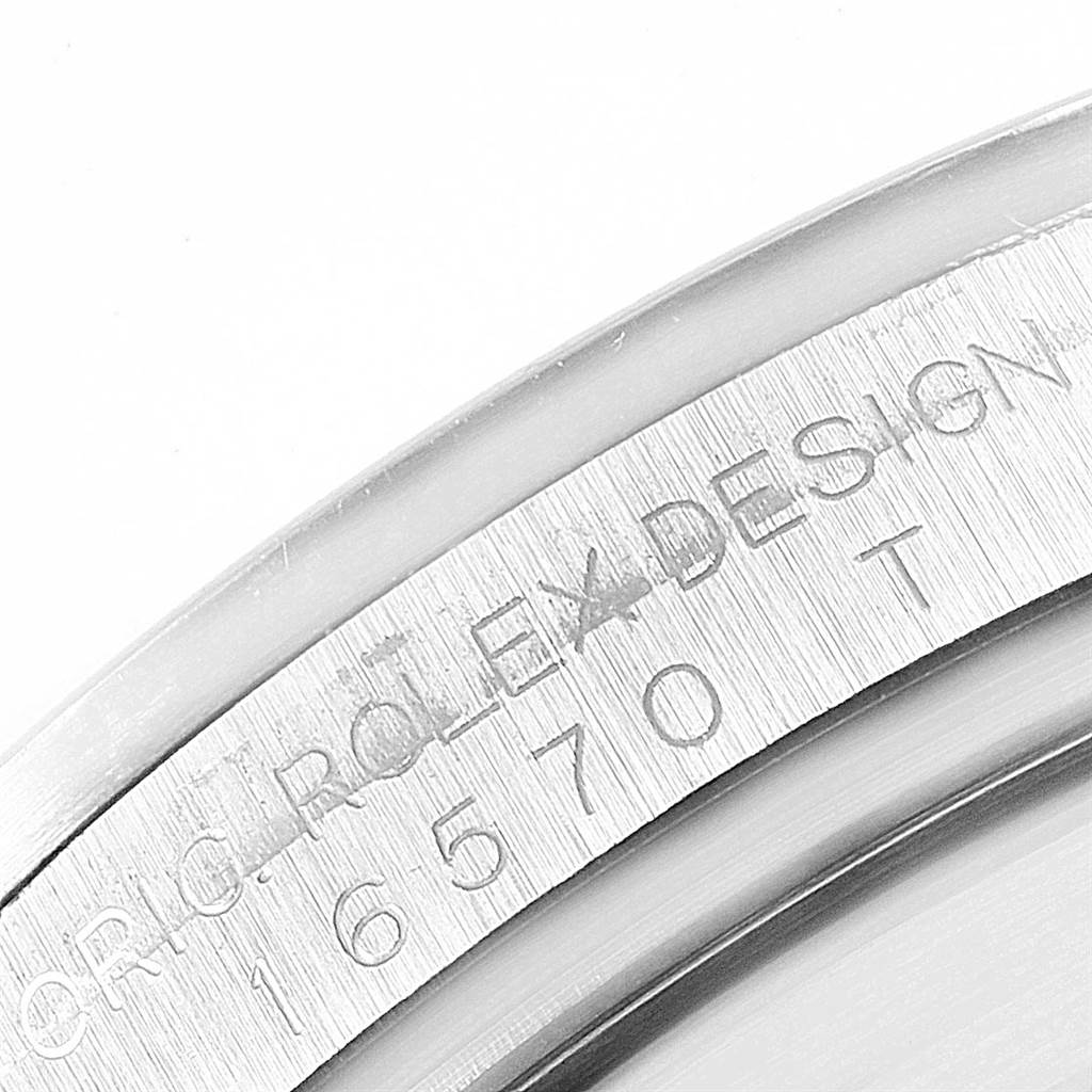 The image shows a close-up of the engraved serial number on the bezel of a Rolex Explorer 16570 Men's Stainless Steel White Dial 16570 Men's Stainless Steel White Dial watch.