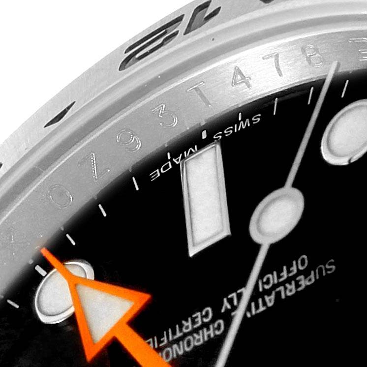 The image shows a close-up angle of a Rolex Explorer 216570 Men's Stainless Steel Black Dial 216570 Men's Stainless Steel Black Dial watch, highlighting part of the bezel, dial, and orange hand.