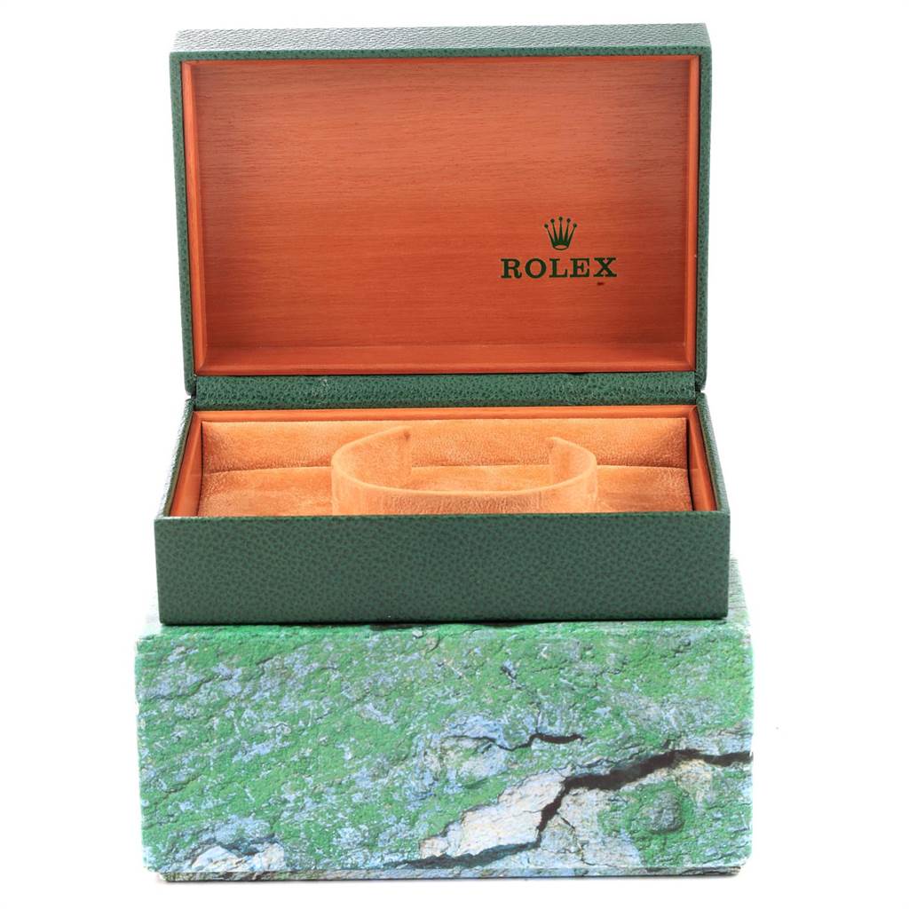 This image shows an open green Rolex box for the Explorer model, featuring its logo inside the lid and a cushion for the watch.