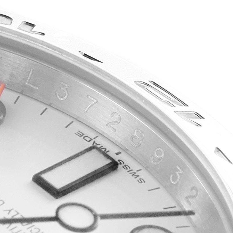 A close-up angle of the Rolex Explorer 216570 Men's Stainless Steel White Dial 216570 Men's Stainless Steel White Dial model shows part of the dial, bezel, and hour markers.