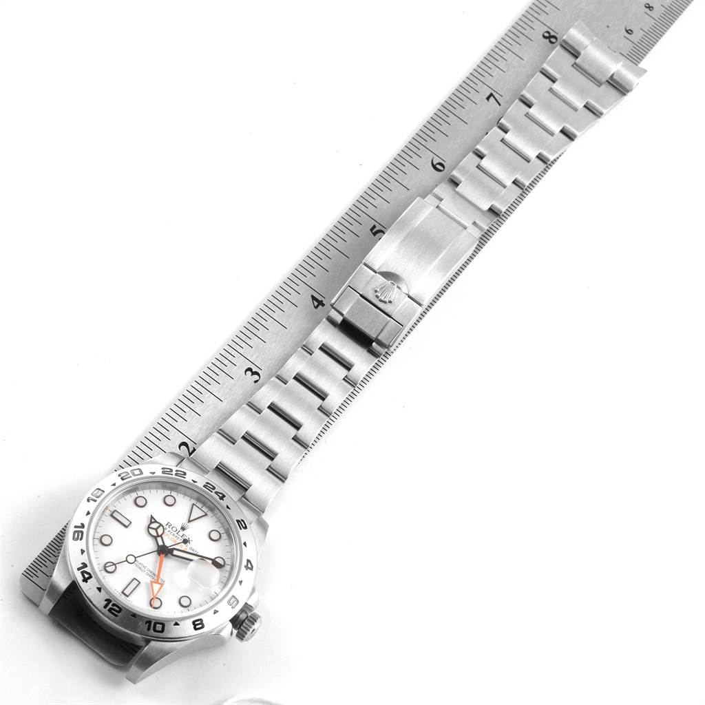The image shows a top-down view of a Rolex Explorer 216570 Men's Stainless Steel White Dial 216570 Men's Stainless Steel White Dial watch, highlighting the bracelet and clasp alongside a ruler for scale.