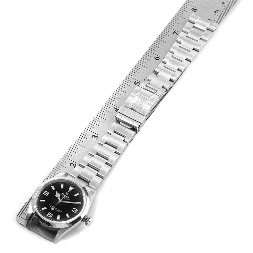 The image shows a Rolex Explorer 114270 Men's Stainless Steel Black Dial 114270 Men's Stainless Steel Black Dial watch laid flat with a ruler beside it, displaying its face and bracelet.