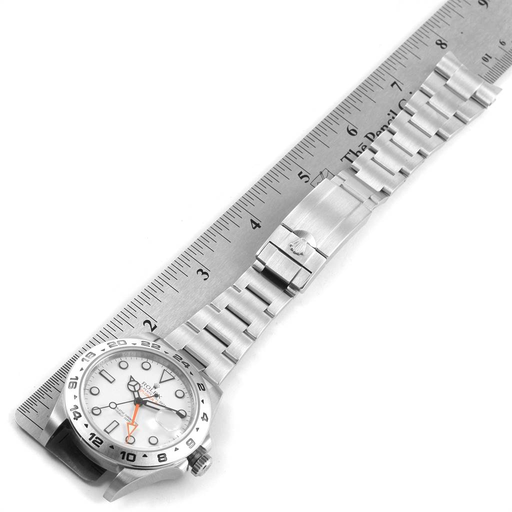 The image shows the Rolex Explorer 216570 Men's Stainless Steel White Dial 216570 Men's Stainless Steel White Dial watch laid flat next to a ruler, displaying the face and bracelet in a top-down angle.