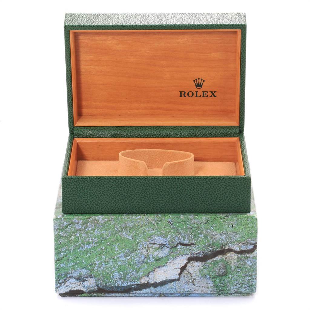 The image shows an open, empty Rolex watch box for the Explorer model, revealing its green exterior and wooden interior.