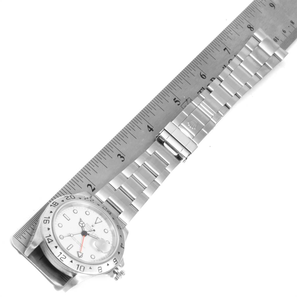 The image shows a top view of a Rolex Explorer 16570 Men's Stainless Steel White Dial 16570 Men's Stainless Steel White Dial watch, including its bezel, dial, and bracelet, placed alongside a ruler.