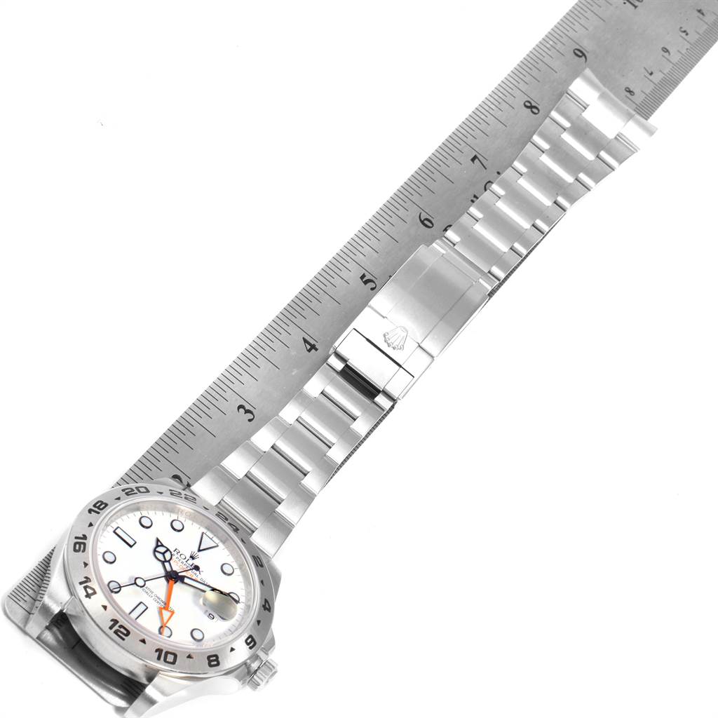 The image displays a Rolex Explorer 216570 Men's Stainless Steel White Dial 216570 Men's Stainless Steel White Dial watch laid flat, showing the face, bracelet, and clasp, with a ruler for scale.